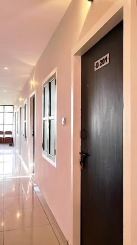 a black door with a sign on it in a hallway at SEA BREEZE RELAX INN in Kannur