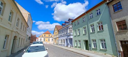 un coche blanco aparcado en una calle con edificios en Apartment 4 in Altstadt in Angermünde, en Angermünde