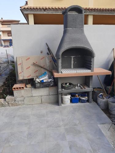 a outdoor oven sitting next to a wall with boxes at ARC BLEu in Siniscola