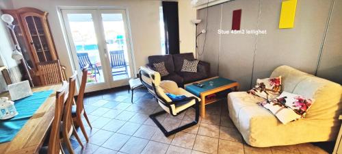 a living room with two chairs and a couch and a table at Helt i Vannkanten as in Åkrehamn