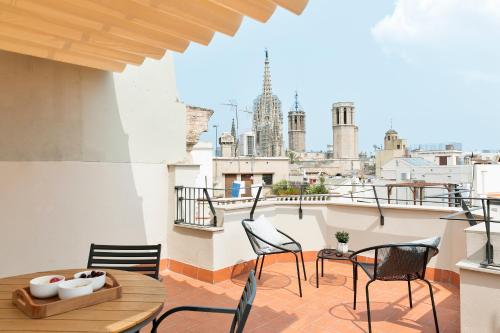 a balcony with chairs and tables and a view of the city at BCN Town Apartments Portaferrissa in Barcelona