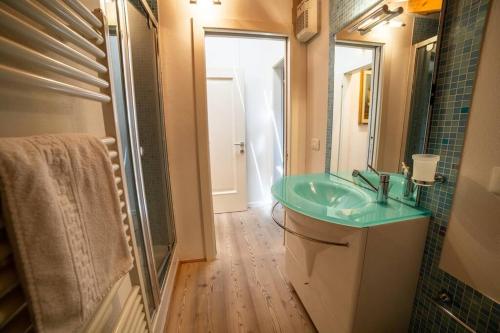 a bathroom with a green sink and a mirror at Attico in centro a Folgaria in Folgaria