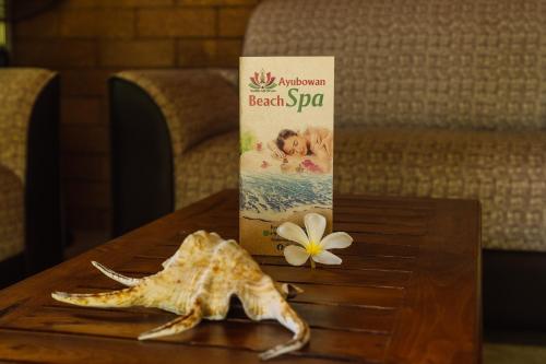 a starfish on a table with a book and a flower at Ananthaya Beach in Tangalle