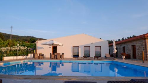eine Villa mit einem Pool und einem Haus in der Unterkunft Quinta de Real in Valença