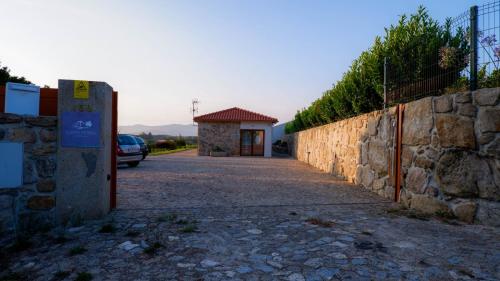 a stone wall with a gate and a building at Quinta de Real in Valença