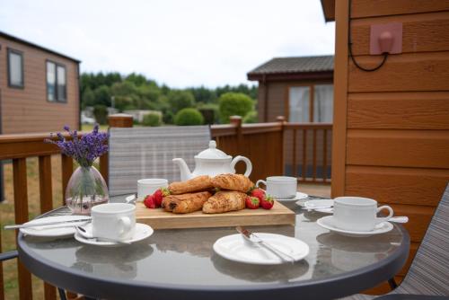 una mesa con galletas y un set de té en el patio en Driftwood Lodge, en Ilfracombe
