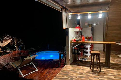 um quarto com uma piscina, uma mesa e cadeiras em Chale elegante c hidromassagem no Alto Paraiso GO em São Jorge