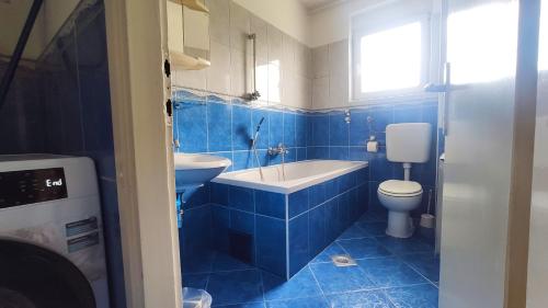 bagno piastrellato blu con servizi igienici e lavandino di Plitvice Apartment a Laghi di Plitvice