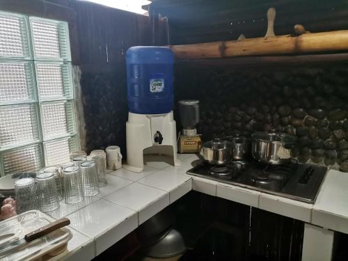 uma cozinha com um fogão e uma bancada com panelas e frigideiras em CABAÑAS ECOLOGICAS STEPHANIE JIRETH em Tonsupa