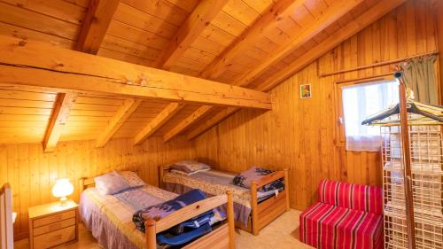a log cabin with two beds and a chair at 35 CHALET - Chalet lumineux 6 pers in Morillon