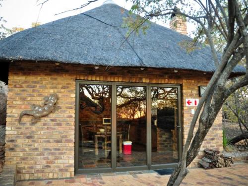 a small brick building with a large glass window at Mokuru Private Nature Reserve in Brits
