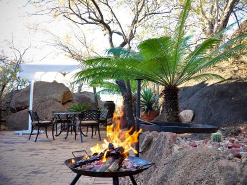 a fire pit in a patio with a table and chairs at Mokuru Private Nature Reserve in Brits