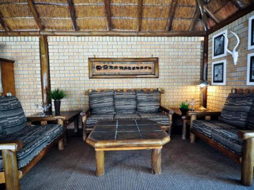 a room with couches and a table and benches at Mokuru Private Nature Reserve in Brits