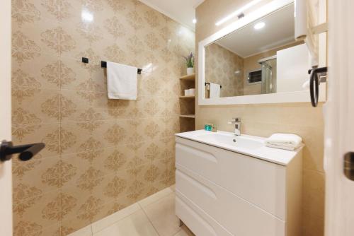 a bathroom with a white sink and a mirror at Bravissimo Figuerola, Spacious 3-bedroom apartment in Girona