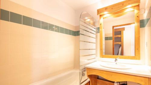 une salle de bain avec un lavabo, un miroir et une baignoire dans l'établissement V du Bachat Silene D31 - 6 pers, à Chamrousse