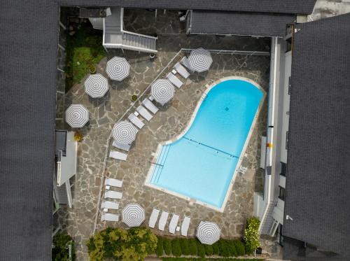 an overhead view of a pool with chairs and umbrellas at A Wave Inn - Montauk in Montauk