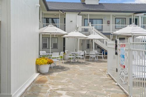a patio with tables and chairs with umbrellas at A Wave Inn - Montauk in Montauk