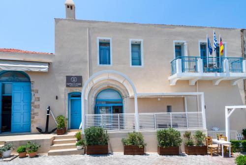 un edificio con porte blu e balcone di Captain's House Hotel Suites & Apartments a Panormos