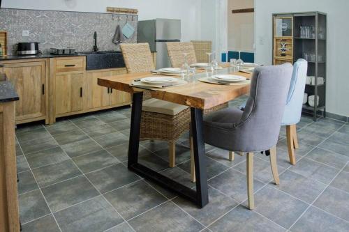 une cuisine avec une table et des chaises en bois dans l'établissement La Thorésienne, à Thorée-les-Pins