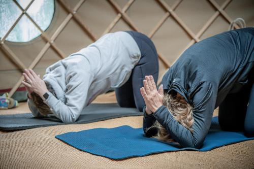 two people are doing yoga in a room at Montigo Resorts, Somerset in Shepton Mallet