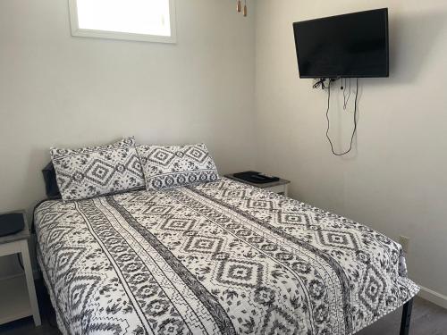 um quarto com uma cama com um edredão e uma televisão em Cottage in Arbor Terrace Resort em Bradenton