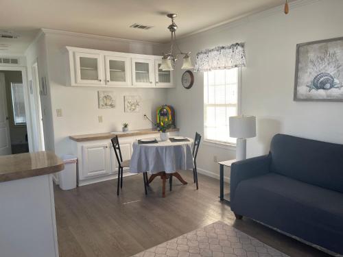 a living room with a table and a blue couch at Cottage in Arbor Terrace Resort in Bradenton