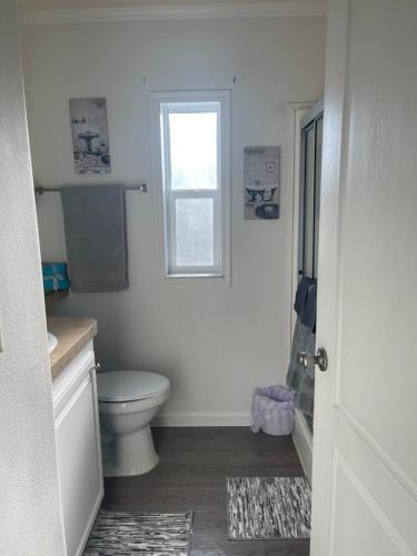 a white bathroom with a toilet and a window at Cottage in Arbor Terrace Resort in Bradenton