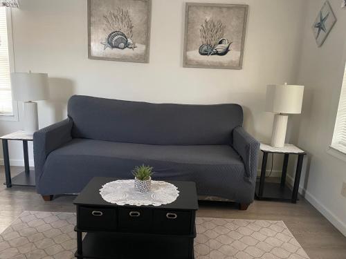 a living room with a blue couch and two tables at Cottage in Arbor Terrace Resort in Bradenton