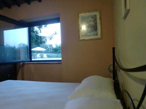 a bedroom with a bed next to a window at I Massi in San Michele in Teverina