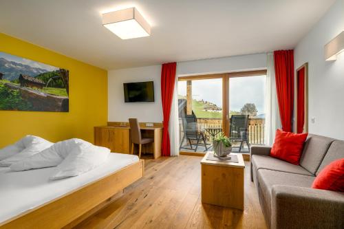 a bedroom with a bed and a couch at Hotel Schmiedhof in Maranza