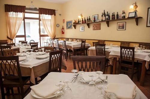 un restaurant avec tables et chaises et nappes blanches dans l'établissement Casa Vacanze A Due Passi dal Mare, à Portopalo di Capo Passero