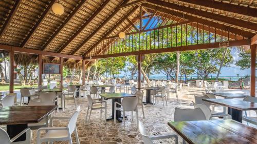 a restaurant with tables and chairs and a view of the ocean at Marien Puerto Plata in San Felipe de Puerto Plata