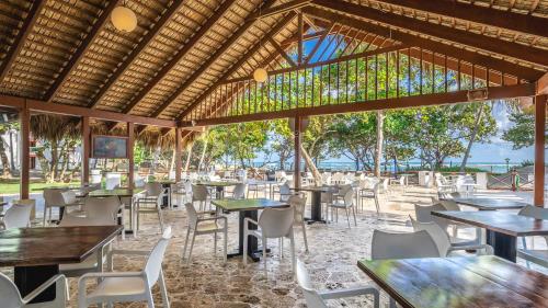 ein Restaurant mit Tischen und Stühlen und Meerblick in der Unterkunft Marien Puerto Plata in San Felipe de Puerto Plata