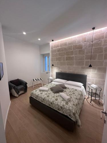 - une chambre avec un lit et un mur en briques dans l'établissement Il Tufo In Festa, à Matera