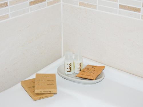 a white counter with two bottles on a plate at Antica Dimora Siracusa in Arenella