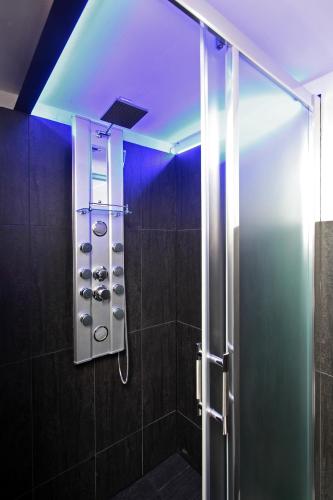 a bathroom with a shower with a blue light at Apartment House - The Modern Flat in Prague