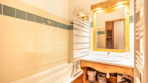 a bathroom with a sink and a mirror and a tub at V DU BACHAT - Silene D11 in Chamrousse
