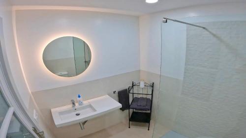a white bathroom with a sink and a mirror at Apartamento Tierra, Primera línea Mar in Playa Honda