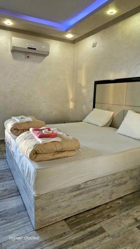 a large bed in a bedroom with a blue ceiling at Al Namteh Lodge in ‘Ābil