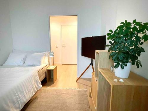 ein Schlafzimmer mit einem Bett und einer Topfpflanze in der Unterkunft Stunning 90 square meter apart with 3br + rooftop in Tampere