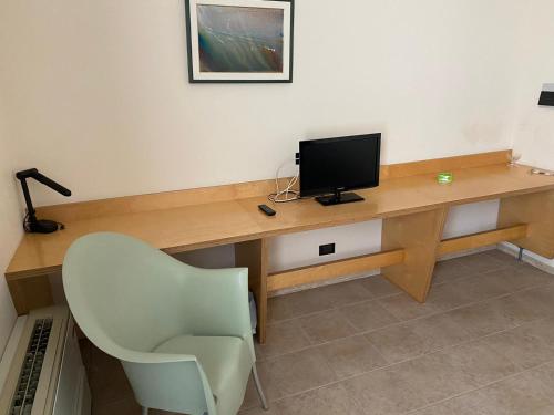 a desk with a monitor and a chair in a room at Albergo Ristorante Saverino in Valderice