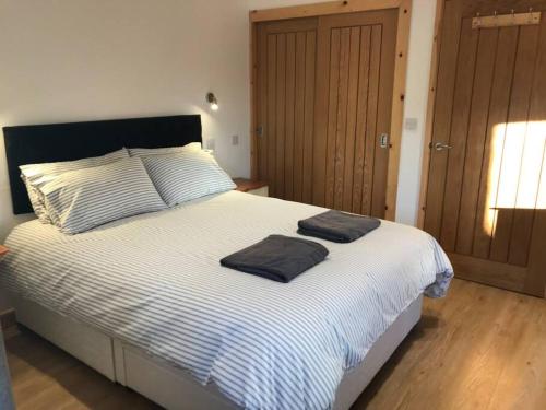 a bedroom with a bed with two towels on it at Piglets. Spacious, Modern, Peaceful, nr Port Isaac in Camelford