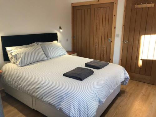 une chambre avec un lit avec deux serviettes dessus dans l'établissement Hendra Retreat Piglets Cottage North Cornwall, à Camelford