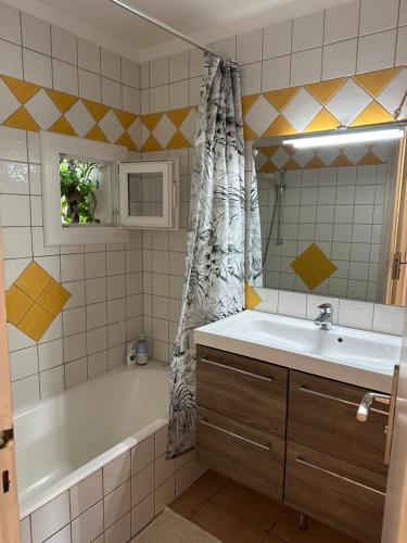 a bathroom with a tub and a sink and a bath tub at La Ramade de Saint-Tropez in Saint-Tropez