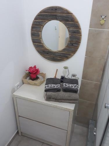 a bathroom with a mirror and towels on a dresser at Hanna's Place - Great Location in Eilat
