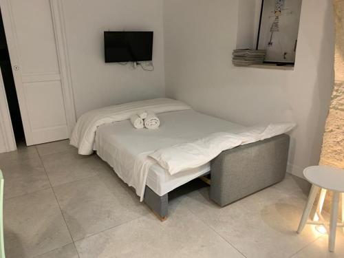 ein kleines Bett in einem Zimmer mit einem TV in der Unterkunft Area 2 in Syrakus