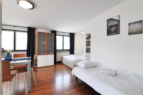 a living room with two beds and a desk at PrimoPiano - Euclide in Milan