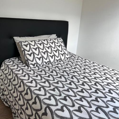 a bed with a black and white comforter and a pillow at VILLA LIDO - Lake Como in Colico