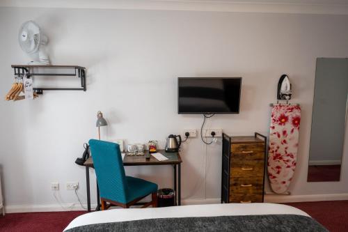 a bedroom with a desk and a tv and a bed at Rising Sun Hotel by Greene King Inns in Cheltenham
