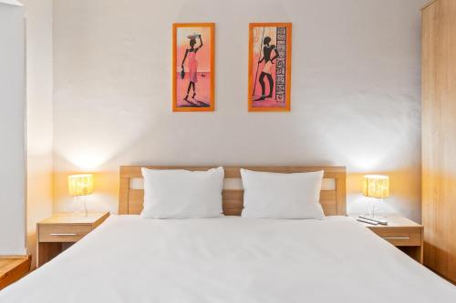 ein Schlafzimmer mit einem großen weißen Bett mit zwei Lampen in der Unterkunft Apartament Helena in Oradea